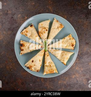 Naan-Brotscheiben im Kreis auf einer blauen Platte, Stockfoto