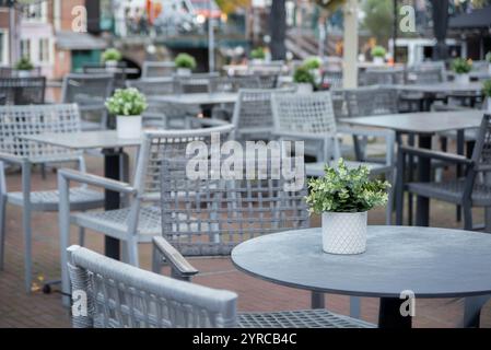 Ein charmantes Café in Leiden, Niederlande, mit Sitzgelegenheiten im Freien an einem Kanal. Mit weißen Tischen mit Topfpflanzen und Korbstühlen, leiden, niederlande Stockfoto