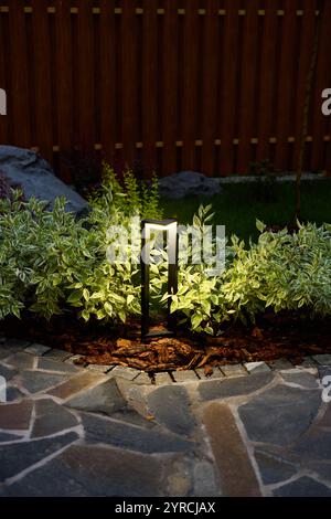 Moderne Gartenbeleuchtung, die die Ästhetik und Schönheit im Freien in der Abenddämmerung und am Abend verbessert Stockfoto