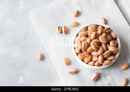 Pistazien-Nuss in Nuss auf rustikalem Hintergrund in Schüssel, Zusammensetzung von Pistazien ideal für gesunde und diätetische Ernährung. Konzept der Nüsse Stockfoto