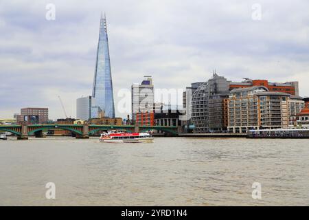 Panoramablick auf Londons Skyline mit berühmten Gebäuden des Stadtzentrums, der Themse und einer Brücke über das Wasser bei Sonnenuntergang. Stockfoto