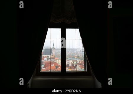 Cesky Krumlov, Tschechische Republik - 26.10.2024: Ein atemberaubendes Panorama von Cesky Krumlov aus einem Burgfenster mit dem bezaubernden Dach der Stadt Stockfoto