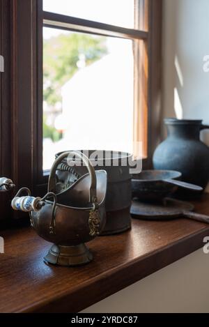 Auswahl an schönen Töpfen und Pfannen im Retro-Stil auf einer Fensterbank in einem alten Haus in Polen Stockfoto