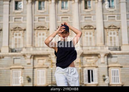 Eine junge Frau posiert selbstbewusst vor einem historischen Gebäude Stockfoto