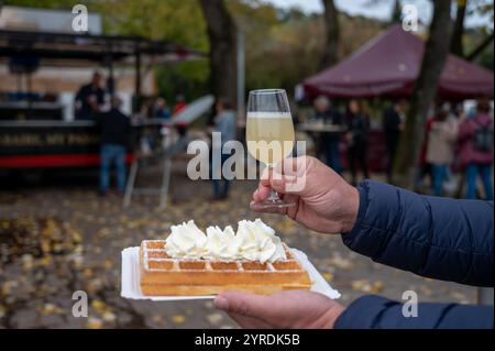 Weinfest in Schengen, Luxemburg, französischen oder luxemburgischen Waffeln mit Schlagsahne und einem Glas Jungwein, der im Herbst im Freien gegessen wird Stockfoto
