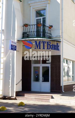 Mogilev, Weißrussland - 21. Juni 2024: Ein modernes Bankgebäude mit einer stilvollen Fassade mit Balkonpflanzen. MT Bank Inschrift auf Russisch Stockfoto