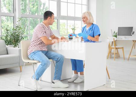 Endokrinologin zeigt Schilddrüsenmodell beim Mann in der Klinik Stockfoto