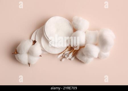 Baumwollkugeln mit Pads, Tupfern und Blume auf beigefarbenem Hintergrund Stockfoto
