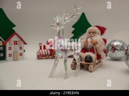 Santa Claus auf Schlitten und Glas-Rentier. Minimale Zusammensetzung Stockfoto
