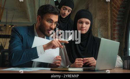 Arabian Mann Geschäftsmann weibliche Geschäftsfrauen muslimische Hijab Frauen im Büro Talk Videoanruf Laptop verärgert wütend Boss männlicher Führer schreien Ärger Stockfoto