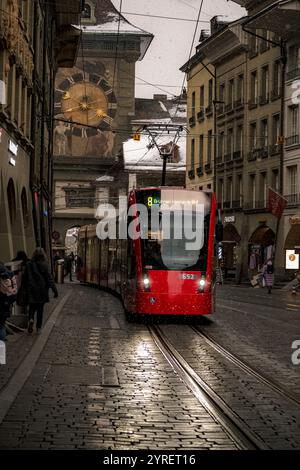 Ein malerischer Blick auf Berns Straßen und Straßenbahnen, die während Weihnachten mit Schnee bedeckt sind, und fängt den festlichen Charme und das winterliche Ambiente ein. Stockfoto