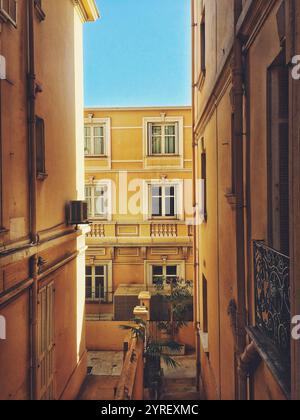 Sonnige Straße in monaco mit farbenfrohen Gebäuden und Pflanzen, perfekt für einen ruhigen Urlaub an der französischen riviera Stockfoto