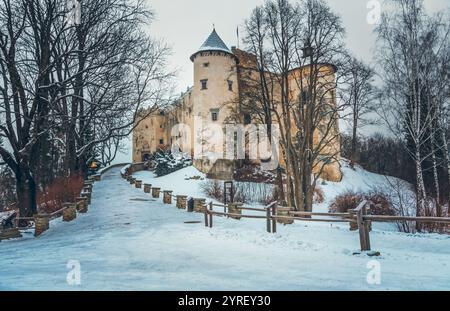Die Burg Niedzica, eine mittelalterliche Festung, erhebt sich majestätisch auf einem Hügel mit Blick auf eine schneebedeckte Landschaft in der ruhigen Wintersaison Stockfoto
