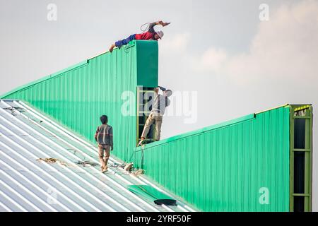 SAMUT PRAKAN, THAILAND, 26. Oktober 2024, Arbeiter arbeiten auf dem Dach der Halle Stockfoto