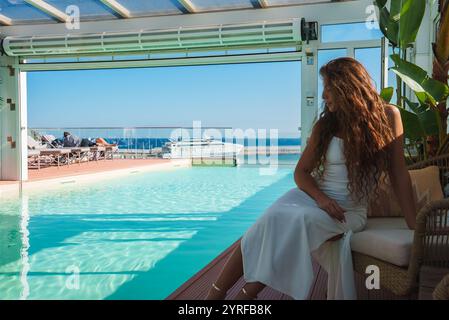 Luxuriöses Hallenbad mit Meerblick und Yacht im Hintergrund Stockfoto