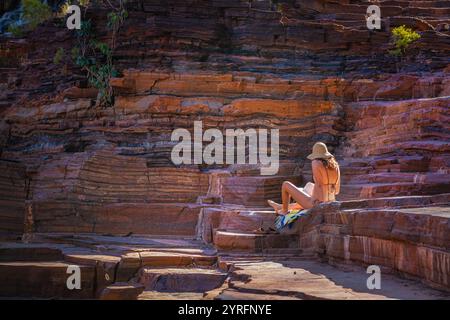 Lesen und Entspannen in Fortescue Falls, Karijini Nationalpark Stockfoto