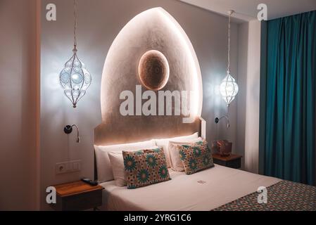 Luxuriöses Hotelzimmer im Marrakesch-Stil mit gewölbtem Kopfteil und Lampen Stockfoto