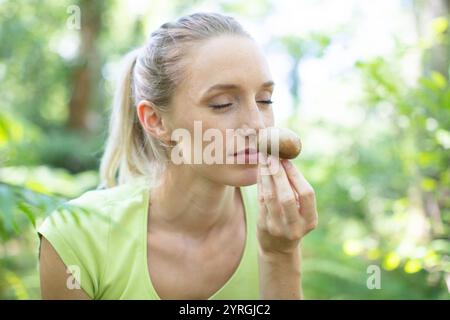 Frau genießt den Geruch frisch gepflückter Wildpilze Stockfoto