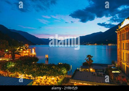 Dämmerung in bellagio, italien, beleuchtete Gebäude, farbenfroher Himmel, ruhiges Wasser, und die umliegenden Berge schaffen eine malerische Szene Stockfoto