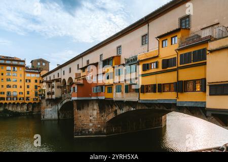 Ponte vecchio, die einzige Brücke in florenz, die während des Zweiten Weltkriegs von der Zerstörung verschont blieb, beherbergt entlang der Brücke erbaute Geschäfte, die sich auf dem Fluss arno spiegeln Stockfoto