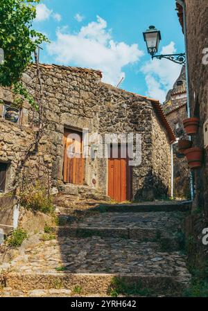 Traditionelle Steinhäuser mit Holztüren und einer kopfsteingepflasterten Gasse, die in das historische Dorf monsanto, portugal, führt Stockfoto