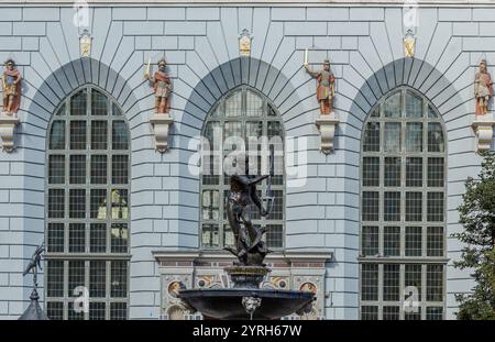 Neptun-Brunnen in danzig, polen, mit Bronzestatue, verzierten Details und Hintergrund der bogenförmigen Fenster und Soldatenstatuen der großen Waffenkammer Stockfoto