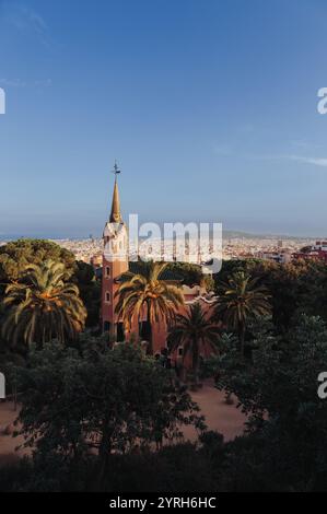 Casa Museu Gaudi im Park güell mit seinen bunten Gebäuden und Palmen bietet einen atemberaubenden Blick auf die Skyline von barcelona unter dem klaren blauen Himmel Stockfoto