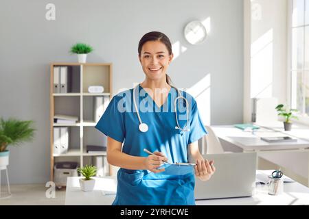 Porträt einer jungen Ärztin in blauer medizinischer Uniform, die in die Kamera schaut. Stockfoto