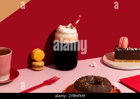 Ein herrlicher Brunch mit einem Schokoladen-Donut mit Streuseln, farbenfrohen Macarons, einem Stück Schokoladenkuchen und dampfendem Kaffee, alles gegen einen Stockfoto