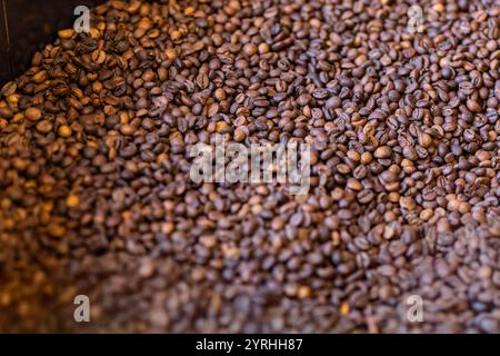 Bei einem Blick aus der Nähe auf einen strukturierten Haufen frisch gerösteter Kaffeebohnen heben die satten Brauntöne die komplexen Details hervor und fesseln die Essenz von Kaffee Stockfoto