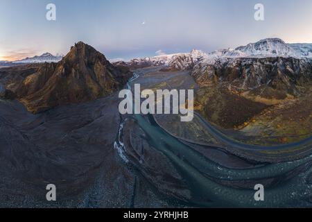 Atemberaubender Blick aus der Vogelperspektive auf das Thorsmork-Tal in Island, mit einem gewundenen Fluss inmitten eines weiten, zerklüfteten Geländes mit schneebedeckten Bergen unter einem klaren, Stockfoto