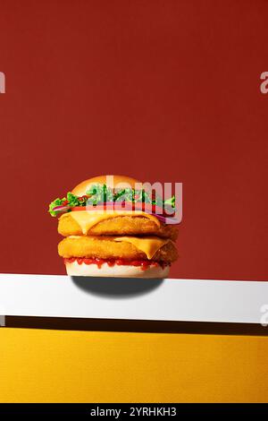 Köstlicher gebratener Hähnchenburger in kräftigen Farben und sauberer Komposition, perfekt für Fast Food-Themen Stockfoto