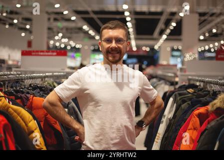Ein Mann schaut sich Schuhe und Kleidung in einem Laden an Stockfoto
