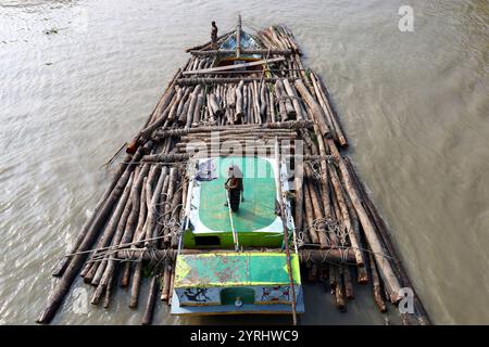 Swarupkathi, Pirojpur, Bangladesch. Dezember 2024. Händler kaufen Holz auf dem größten schwimmenden Holzmarkt in Bangladesch in Swarupkathi upazila im Bezirk Pirojpur und transportieren es in großen Booten. Der Markt bietet eine große Auswahl an einheimischen Hölzern, darunter Mahagoni, Champagner und raintree. Händler aus dem ganzen Land kaufen auf diesem Upazila-Markt Holz im Wert von einem Lakh-Dollar. Diese Hölzer werden dann auf verschiedenen Wegen durch das ganze Land transportiert, darunter LKW, Starts und Frachtschiffe. Tausende von Menschen in Swarupkathi sind tief in diese blühende Holzart verwickelt Stockfoto