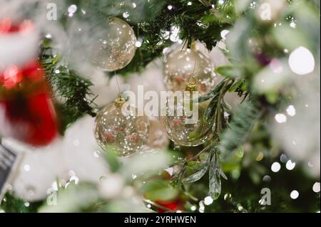 Ein Baum mit einem Haufen Weihnachtsschmuck. Die Ornamente sind meist klar und glänzend Stockfoto