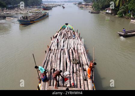 Swarupkathi, Pirojpur, Bangladesch. Dezember 2024. Händler kaufen Holz auf dem größten schwimmenden Holzmarkt in Bangladesch in Swarupkathi upazila im Bezirk Pirojpur und transportieren es in großen Booten. Der Markt bietet eine große Auswahl an einheimischen Hölzern, darunter Mahagoni, Champagner und raintree. Händler aus dem ganzen Land kaufen auf diesem Upazila-Markt Holz im Wert von einem Lakh-Dollar. Diese Hölzer werden dann auf verschiedenen Wegen durch das ganze Land transportiert, darunter LKW, Starts und Frachtschiffe. Tausende von Menschen in Swarupkathi sind tief in diese blühende Holzart verwickelt Stockfoto