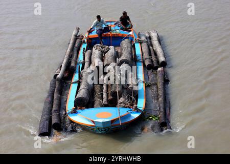 Swarupkathi, Pirojpur, Bangladesch. Dezember 2024. Händler kaufen Holz auf dem größten schwimmenden Holzmarkt in Bangladesch in Swarupkathi upazila im Bezirk Pirojpur und transportieren es in großen Booten. Der Markt bietet eine große Auswahl an einheimischen Hölzern, darunter Mahagoni, Champagner und raintree. Händler aus dem ganzen Land kaufen auf diesem Upazila-Markt Holz im Wert von einem Lakh-Dollar. Diese Hölzer werden dann auf verschiedenen Wegen durch das ganze Land transportiert, darunter LKW, Starts und Frachtschiffe. Tausende von Menschen in Swarupkathi sind tief in diese blühende Holzart verwickelt Stockfoto