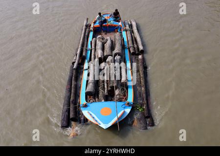 Swarupkathi, Pirojpur, Bangladesch. Dezember 2024. Händler kaufen Holz auf dem größten schwimmenden Holzmarkt in Bangladesch in Swarupkathi upazila im Bezirk Pirojpur und transportieren es in großen Booten. Der Markt bietet eine große Auswahl an einheimischen Hölzern, darunter Mahagoni, Champagner und raintree. Händler aus dem ganzen Land kaufen auf diesem Upazila-Markt Holz im Wert von einem Lakh-Dollar. Diese Hölzer werden dann auf verschiedenen Wegen durch das ganze Land transportiert, darunter LKW, Starts und Frachtschiffe. Tausende von Menschen in Swarupkathi sind tief in diese blühende Holzart verwickelt Stockfoto