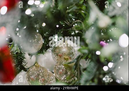 Ein Baum mit einem Haufen Weihnachtsschmuck. Die Ornamente sind meist klar und glänzend Stockfoto