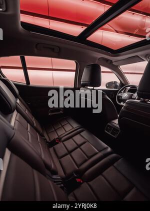 Innenraum des Citroen C5 Aircross. Weitwinkelansicht vom Beifahrersitz: Hintere Sitzreihe, Glasdach und Rückseite der Vordersitze in französischem suv. Stockfoto