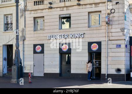 Marseille. Frankreich - 4. Dezember 2024: Dieses Foto zeigt den Haupteingang eines Burger King in einem alten Steingebäude. Das erkennbare sig Stockfoto