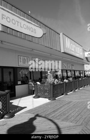 Touristen genießen eine Mahlzeit in einem belebten Straßencafé auf der Promenade in Myrtle Beach, South Carolina, USA. Stockfoto