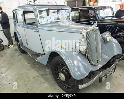 Ein klassischer Oldtimer von Jowett Kestrel aus dem Jahr 1935, der in Innenräumen mit elegantem Design und polierten Details präsentiert wird, umgeben von anderen antiken Fahrzeugen Stockfoto