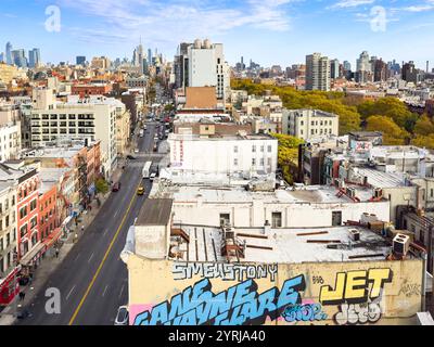 Lebhafter Blick aus der Luft auf bowery chinatown New York City mit Graffiti-Kunst auf Dächern und dem Empire State Building im Hintergrund an klaren Tagen Stockfoto