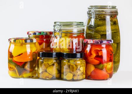 Verschiedene Gläser mit eingelegtem Gemüse, wie Paprika, Pilze und Gurken. Die Gläser sind in verschiedenen Formen und Größen erhältlich, Stockfoto