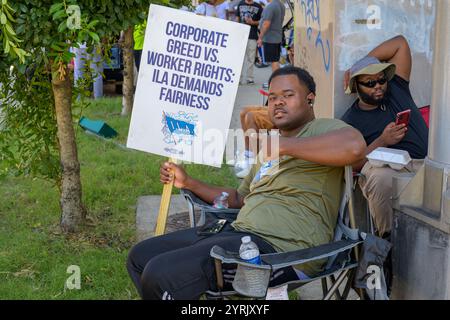 NEW ORLEANS, LA, USA - 2. OKTOBER 2024: Streikarbeiter der International Longshoremen's Association halten ein Streikschild am Eingang zum Hafen von New Orleans Stockfoto