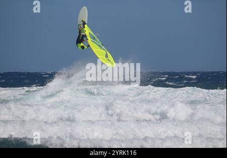 Windsurfer mit gelbem Segel in den Wellen des Atlantischen Ozeans (Teneriffa, Spanien) Stockfoto