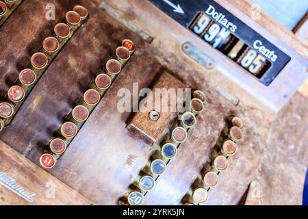 Eine nationale Kasse mit Holztheke und einem Schwarzweißschirm. Der Bildschirm hat ein Dollarzeichen und ein 995-Cent-Zeichen Stockfoto