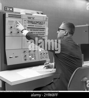 In den 1960er Jahren Innenraum eines Raumes mit Computern und Personen, die mit ihnen umgehen und Informationen registrieren und lesen. Auf einem Schild über dem Mainframe-Computer steht IBM 360. IBM System 360 wurde häufig in der us-amerikanischen Fernsehserie Mad Men gesehen. Foto aufgenommen 1965 Kristoffersson Ref. DY125-7 Stockfoto