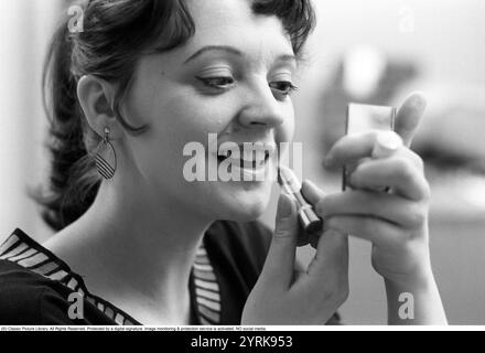 Eva Remaeus. Schauspielerin. (1950–1993) hier während der Dreharbeiten zum Film Sven Klangs Quintett, der am 23. September 1976 in Stockholm seine schwedische Premiere hatte. Man sieht sie glücklich mit einem Lippenstift auf den Lippen. Sie sieht sich im Spiegel an, während sie sich schminkt. Stockfoto